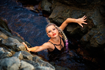 Sexy blonde with a long hair in a swimsuit near the sea