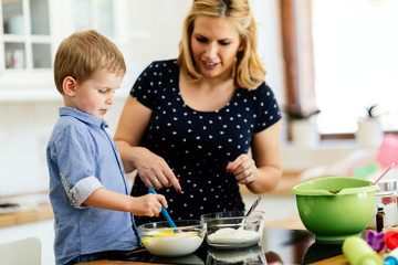 Obraz na płótnie Canvas Beautiful child and mother baking