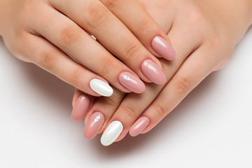 gently pink manicure with white pearly rub on long oval nails with crystals, rhombuses on a white...