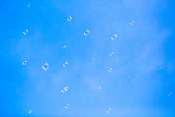 Soap bubbles in flight against the blue sky