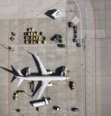View from above commercial airplane being serviced, prepared on tarmac at airport