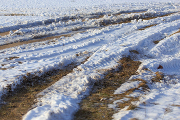 Road dirt in the snow in winter
