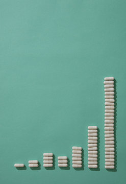 Capsules forming ascending bar graph on green background