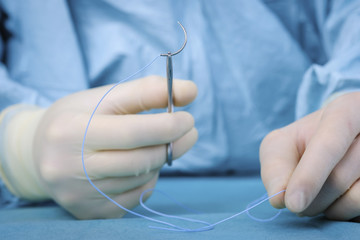 Close up surgeon holding needle