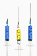 Syringes with blue and yellow liquid