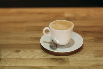 Beautiful cappuccino on a wooden background in cafe