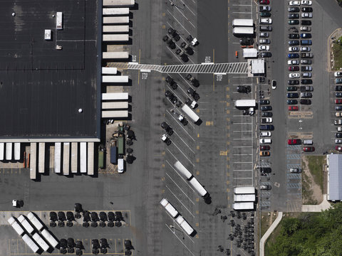 Aerial view sunny parking lot and commercial warehouse, New York City, New York, USA