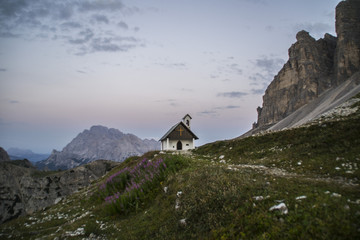 Breathtaking summer scenic landscape view of iconic Cappella degli Alpini chapel while sunrise in famous Tre Cime di Lavaredo mountains in the Dolomites mountain range, South Tirol Alps, Italy, Europe