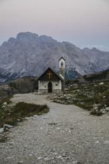 Fototapeta na wymiar Breathtaking summer scenic landscape view of iconic Cappella degli Alpini chapel while sunrise in famous Tre Cime di Lavaredo mountains in the Dolomites mountain range, South Tirol Alps, Italy, Europe