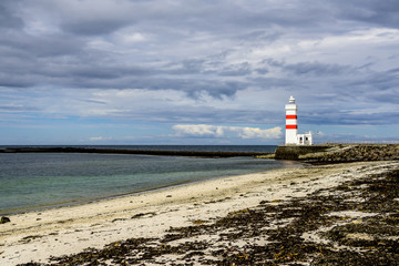 Beautiful Icelandic lighthouse with puffy clouds and calm seas