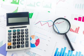 Naklejka na ściany i meble Calculator and Magnifying with Business Graphs finance document.