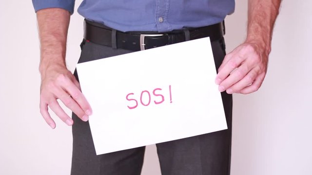 Holding SOS sign below belt