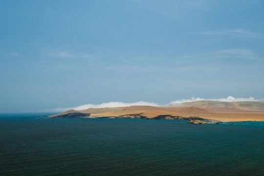 Natural reserve in Paracas, Peru. Blue sky, green sea, yellow cliffs, desert and ocean