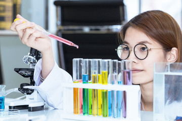 Young female scientist student mixing substances in test tube.Copy space.