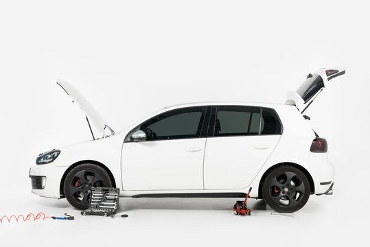 Side View Of Broken White Car With Open Trunk And Open Hood On White