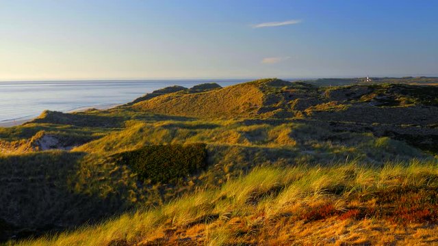 Wundersch&ouml;ner Blick &uuml;ber die D&uuml;nen - Landschaft von Sylt auf das Meer. Im Hintergrund der Leuchtturm von List