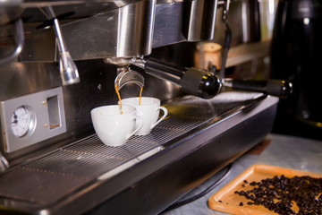 Barista make coffee espresso shot by streaming machine in coffee cafeteria bar. Brewing Process concept. coffee blending process. image for background, wallpaper,decoration and copy space.