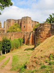 Fototapeta na wymiar Kenilworth Castle ruins sheltered by a high defensive wall on a sunny day,
