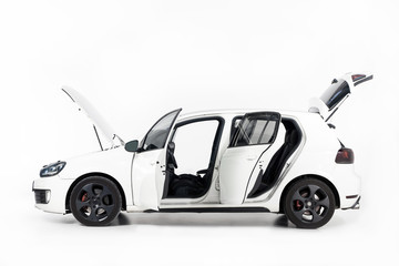 side view of new white car with open doors and open hood on white