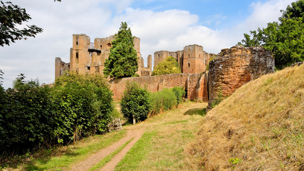 Fototapeta na wymiar View of the ruins of Kenilworth Castle sheltered by a high defensive wall on a sunny day.