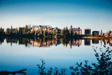 Naklejka premium Beautiful clear reflection of houses by lake. Strbske pleso, Slovakia