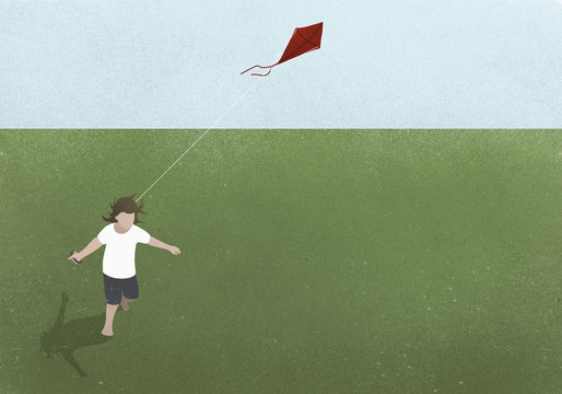Girl running with kite in grassy field