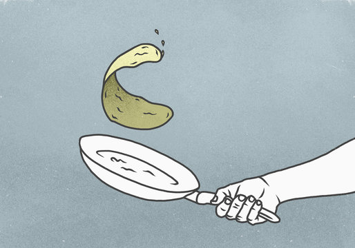 Hand flipping crepe in pan