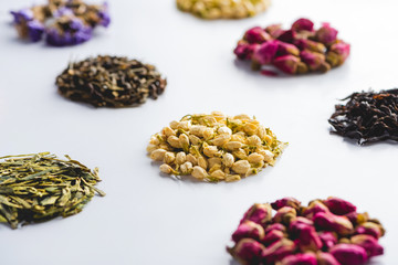 collection of dried herbal healthy tea on white surface
