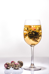 beautiful glass of chinese flowering tea with tea balls on table