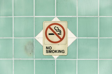 No smoking sign on turquoise tile wall