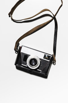 Retro camera and strap on white background