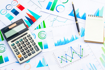 Calculator and Pen on Business Graphs finance document.	