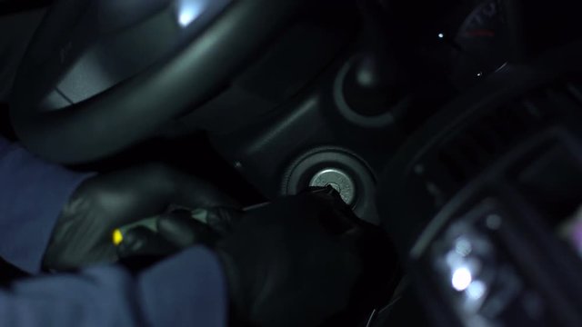 Criminal trying start stolen auto engine with tool, lock picking, urban hooligan
