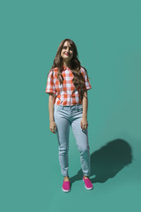 Portrait confident young woman against turquoise background