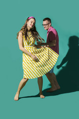 Portrait carefree couple dancing against turquoise background