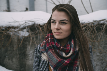 Thoughtful young woman in plaid scarf looking away