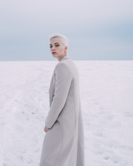 Portrait confident young woman walking in snow