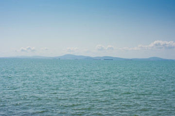 A ship on the horizon of the blue sea.