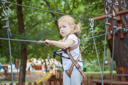 Portrait of a brave little girl in rope park.
