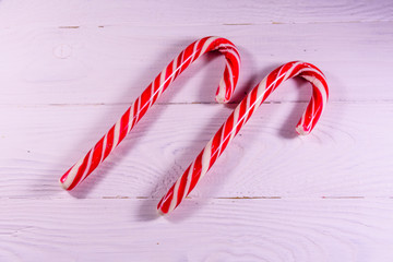 Two candy canes on a wooden table. Top view