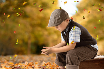 trauriges Kind sitzt auf einem Koffer - Herbst
