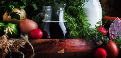 Ingredients for cold soup with vegetables, herbs and meat products, old wooden table, selective focus