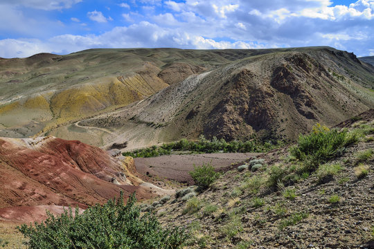 View of unrealy beautiful colorful clay cliffs in Kyzyl-Chin (Kisil-Chin) valley, Altai mountains, Russia. Summer landscape, which is called Martian for its fantastic lifeless beauty