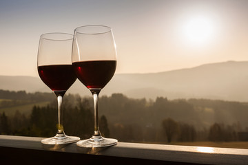 Two wine glasses at sunset time.