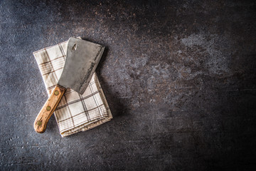 Old meat butcher on dark concrete board