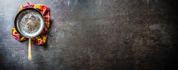 Empty old roast pan on dark concrete board.