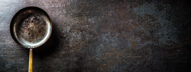 Empty old roast pan on dark concrete board. - obrazy, fototapety, plakaty