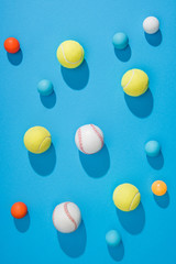 top view of arranged pin pong, tennis and baseball balls on blue background