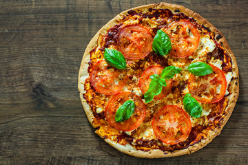 Pizza with Mozzarella cheese, Tomatoes, pepper, Spices and Fresh Basil. Italian pizza. Pizza Margherita or Margarita. on wooden background. with copy space. top view