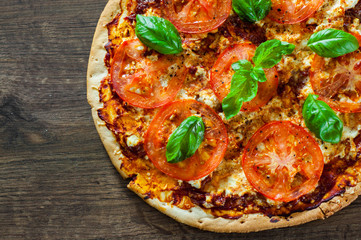 Pizza with Mozzarella cheese, Tomatoes, pepper, Spices and Fresh Basil. Italian pizza. Pizza Margherita or Margarita. on wooden background. with copy space. top view